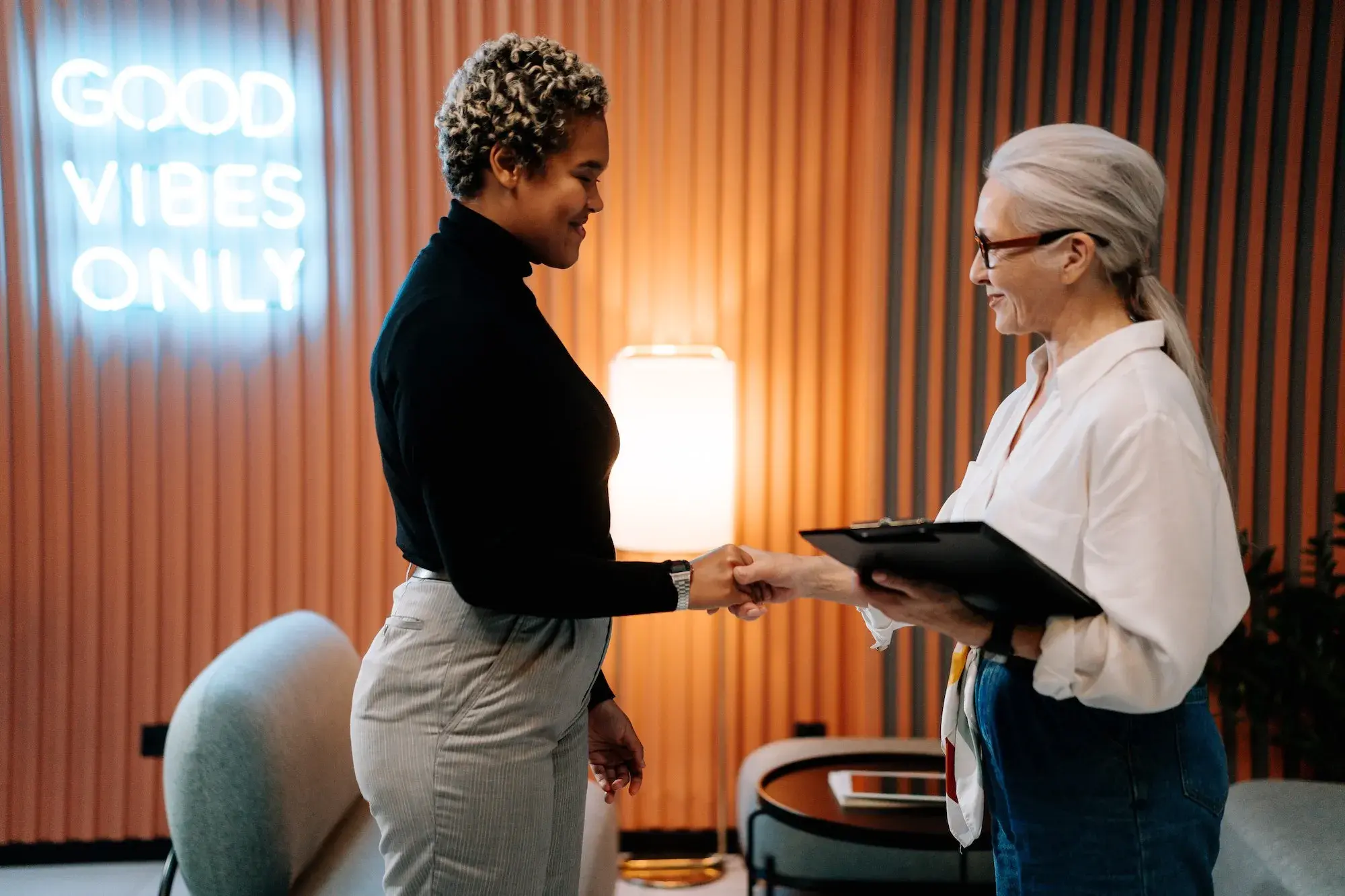 Two women shaking hands in an office