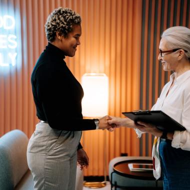 Two women shaking hands in an office